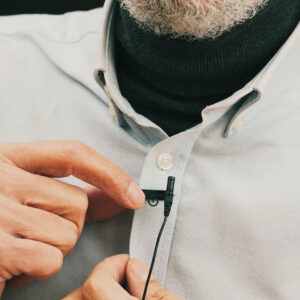 photo of man clipping a lapel microphone to his shirt